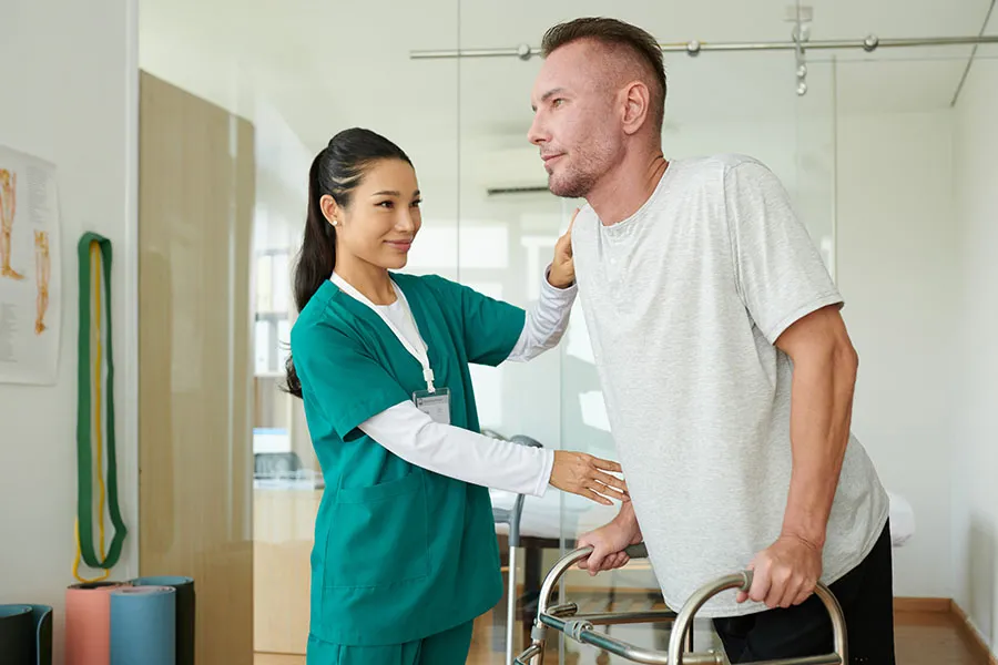 Physical therapist helping a patient during rehabilitation — representing healthcare practices using their websites to explain treatment options, build trust, and attract the right patients.